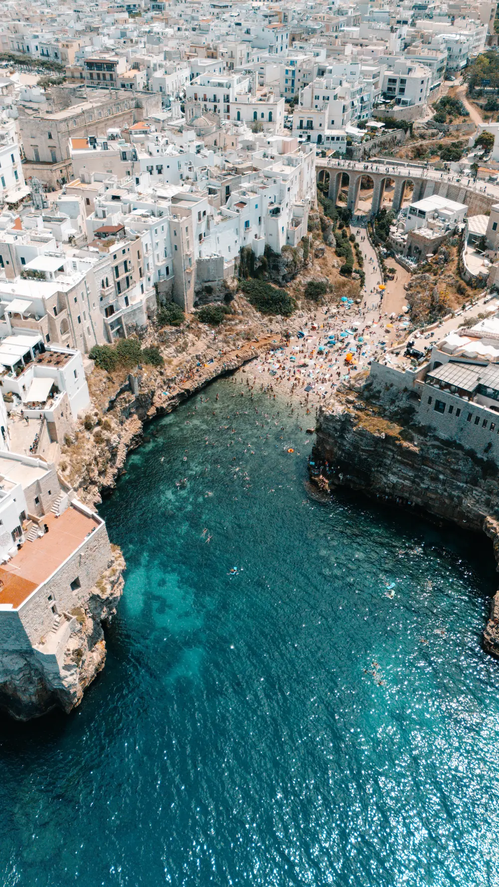 Clifftop town above a turquoise sea cove