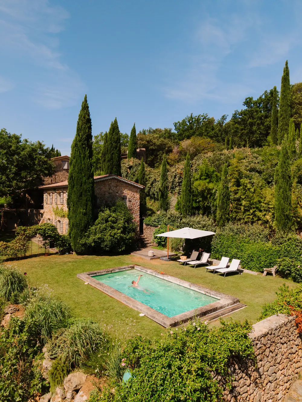 Stone villa with a pool among cypress trees