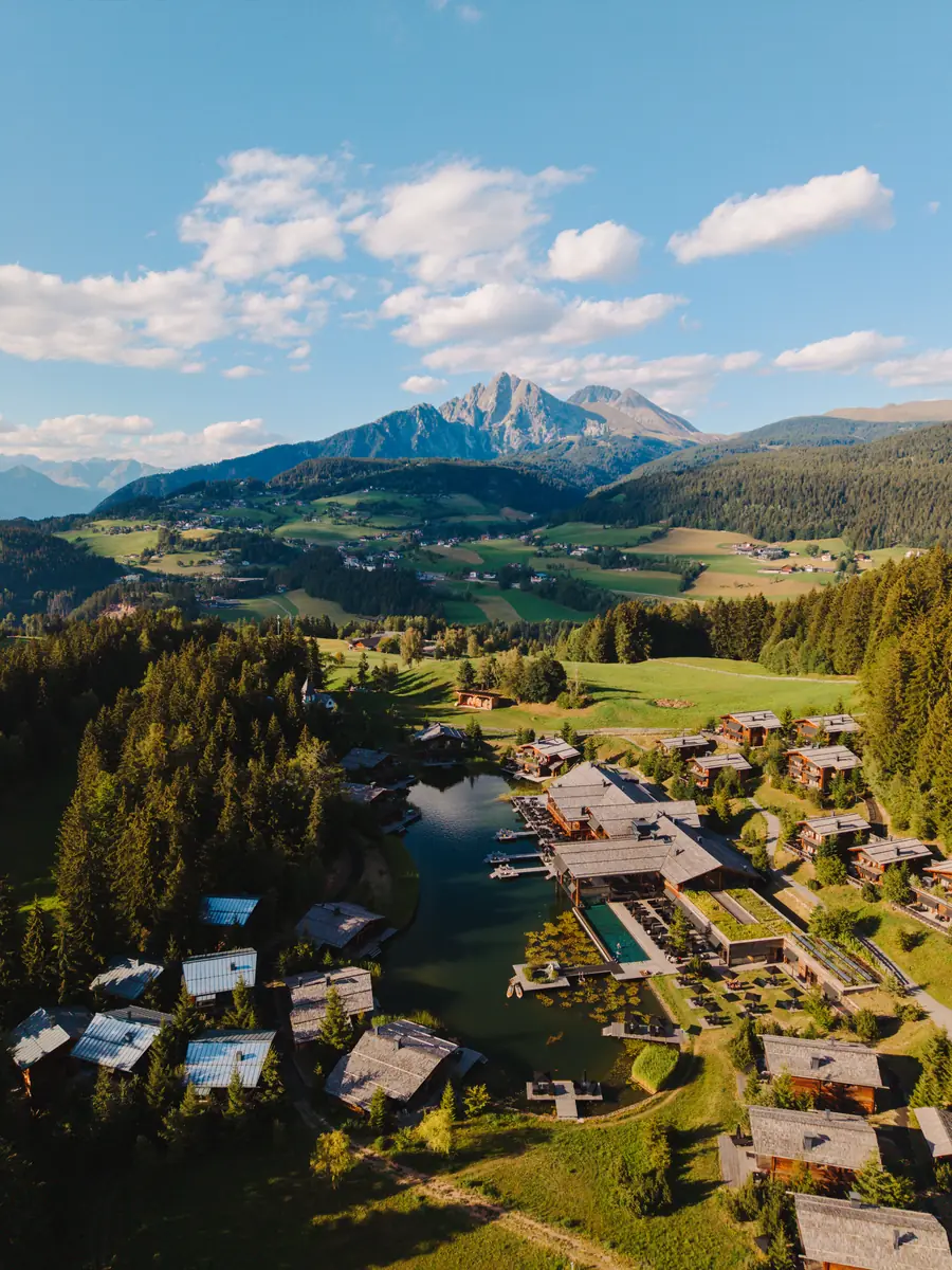 Aerial view of an alpine valley with lodges among the trees