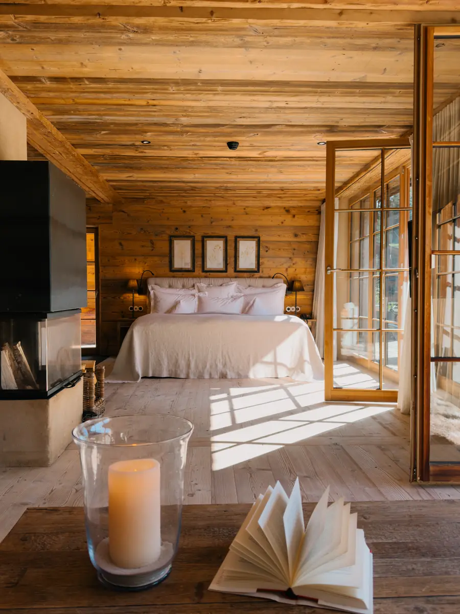 Bedroom with a wooden ceiling, a candle and an open book